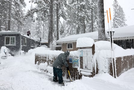 A man shovels snow while his daughter shovels from the roof during a powerful multiple day winter storm in the Sierra Nevada mountains on Saturday in Truckee, California.