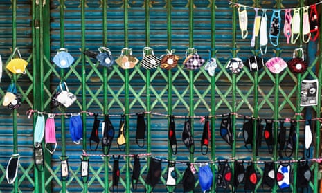 Face masks are displayed on the shutters of a closed shop by a street vendor in Dhaka.