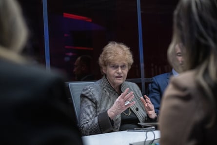 Woman successful grey suit overgarment speaking astatine table.
