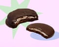 Two chocolate-coated mint slice biscuits with cream filling, each with a bite taken out, on a pastel purple background