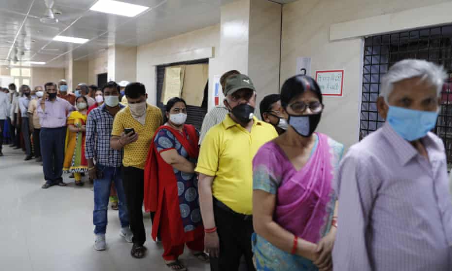 People wait to receive a Covid vaccine in Prayagraj, India