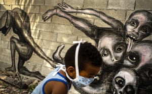 A boy plays in front of a mural by artist Yuriel P called Marcha Hacia la Oscuridad, or Move Toward Darkness, in Havana