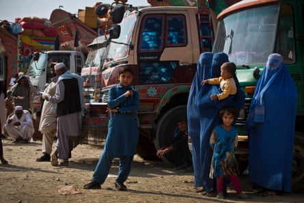 Afghan refugees, who have been forced to leave Pakistan and return to Afghanistan, stand in front of the trucks that have brought them from Pakistan at a UNHCR reception centre on the outskirts of Kabul, Afghanistan Thursday, 29 September.