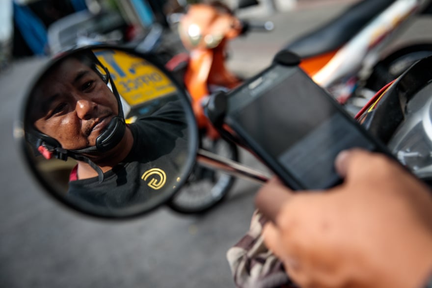 Motorbike taxi driver Poynthep Chatchawaaanamonkul, 42, loads up the Grab app on his phone