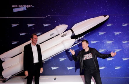 Döpfner and Musk posing in front of a model rocket