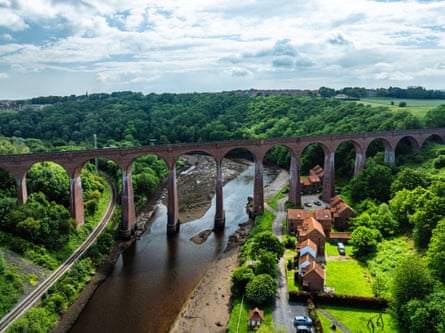 Victorian viaduct with multiple arches over a river in a verdant valley