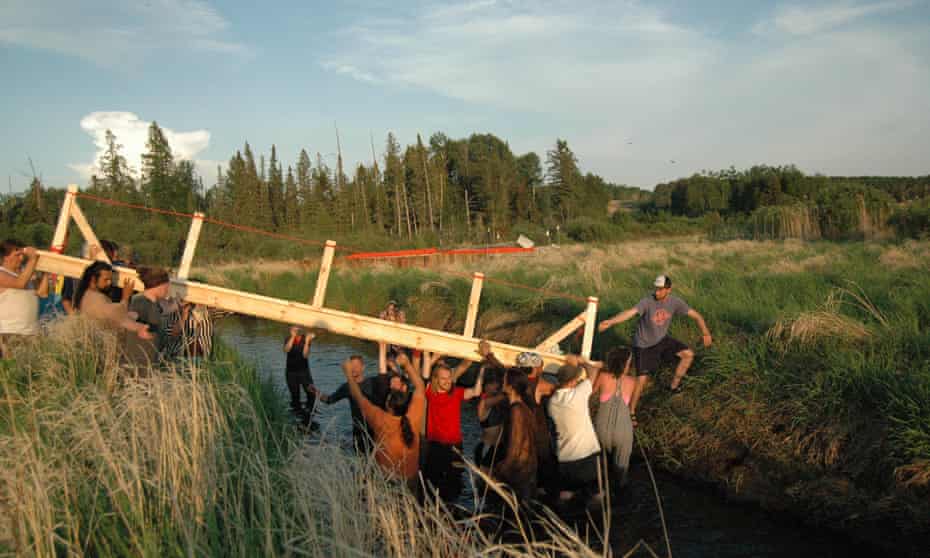 Activists install a bridge over a narrow portion of the Mississippi River.