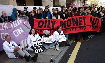 Climate activists hold banners outside the InterContinental London Park Lane during the ‘oily money out’ demonstration against the Energy Intelligence Forum conference, 17 October 2023.