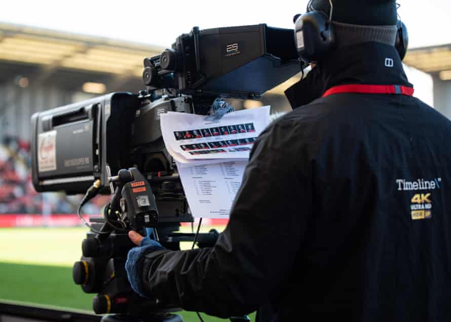A BBC cameraman pins the two team sheets to the camera.