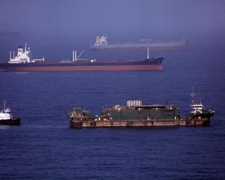 Oil tankers and merchant ships anchor in misty water near the strait of Hormuz