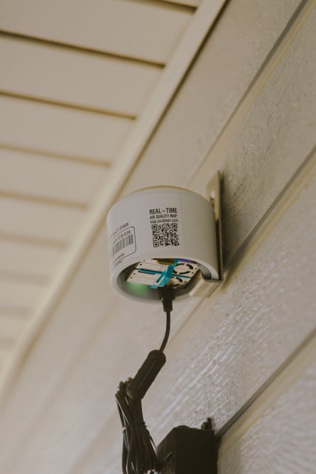 A cylindrical air quality sensor attached to a wall.