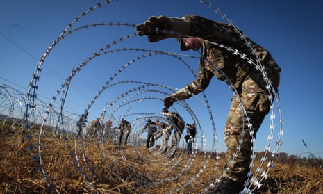 Slovenian soldiers erect razorwire fences on the country’s border with Croatia