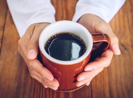 Χέρια που κρατούν μια κούπα μαύρο καφέ