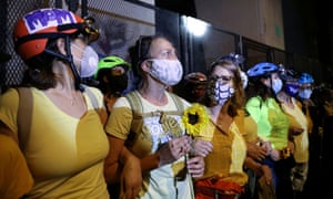 Mothers stand between federal law enforcement officers and protesters during a protest against racial inequality in Portland