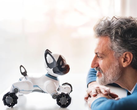 A man looking at a robotic dog.
