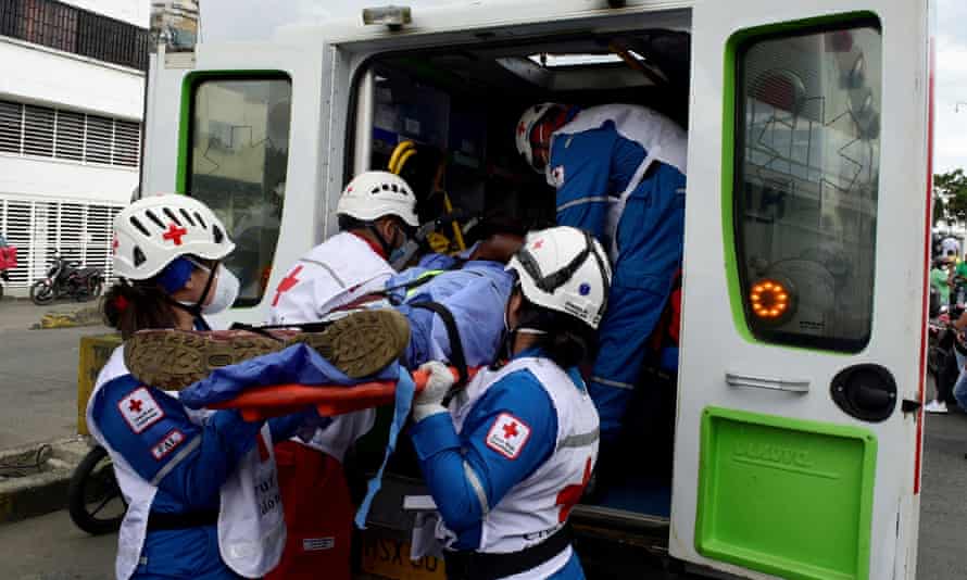 Red Cross paramedics carry the body of an agent of the attorney general’s investigative unit, who opened fire on civilians before being killed.