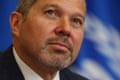Close up of International Maritime Organization secretary-general Arsenio Dominguez with a blue flag taking up the background