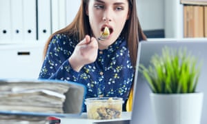 Woman eating at her office desk