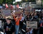 High-school students march through Bordeaux holding handmade cardboard signs and red flags.