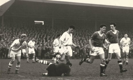 Tommy Taylor and, just behind him, Denis Viollet turn away after Workington’s goalkeeper makes a save during the FA Cup tie at Borough Park. Violett went on to score a hat-trick.