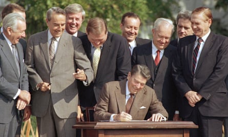Bob Dole, third from left, and other congressmen looking on as President Ronald Reagan signs a landmark tax overhaul at the White House in 1986.