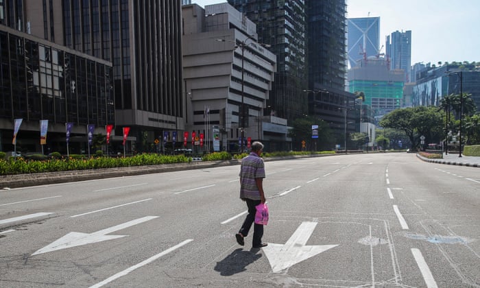 A man walks on an empty street during day three of movement control order (MCO) enforcement in Kuala Lumpur, Malaysia
