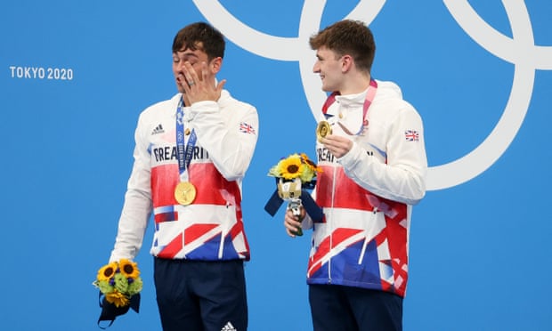 Tom Daley crying on the podium after winning gold at the Tokyo Olympics with Matty Lee.