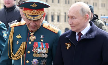 Former defence minister Sergei Shoigu in military dress with Vladimir Putin in a black coat to his right.