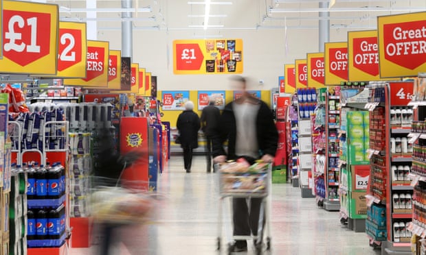 Customers pass along the central aisle inside a Morrisons supermarket