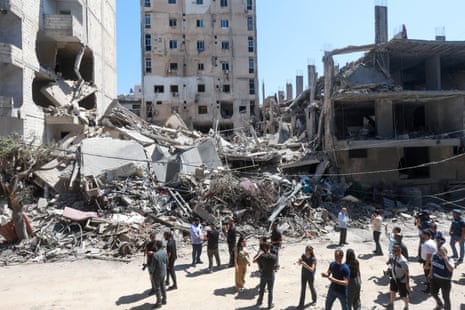 People gather near a building destroyed in an Israeli strike.