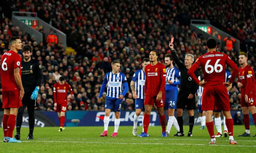 Referee Martin Atkinson shows Liverpool goalkeeper Alisson, second left, a straight red card at Anfield.