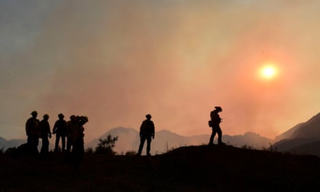 Firefighters position themselves on a ridge overlooking flames from the Bobcat Fire in a valley below in the Angeles national forest on Wednesday.