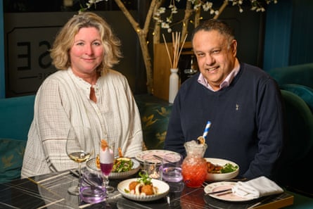 A woman and man next to each other across a restaurant table