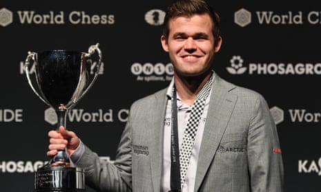 Magnus Carlsen poses with the trophy after winning the world chess championship against Fabiano Caruana.