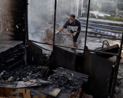 Moha Haddad put out some fire at his house after being allowed to return to it following the wildfires in Navas del Rey, in Madrid province, Spain.