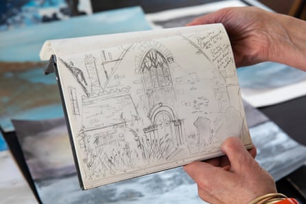 Artists hands showing a drawing of a church