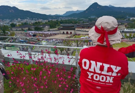 A supporter of impeached former president Yoon Suk Yeol overlooks the anti-China protest.