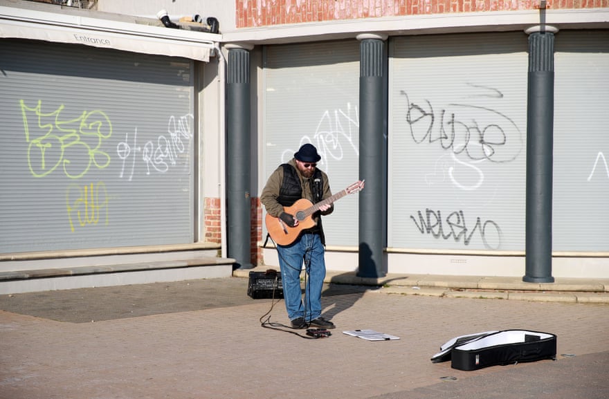 A busker plays on the deserted streets at Brighton beach.