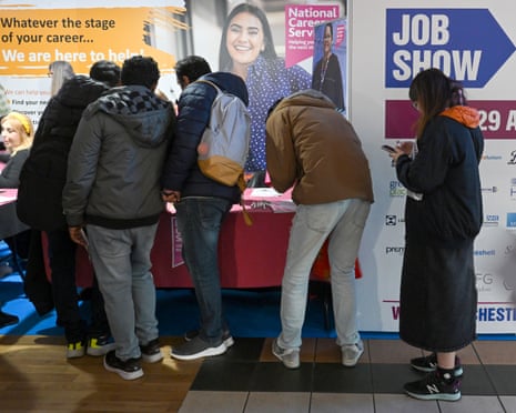 Visitors speak with careers service staff at a jobs show in Manchester