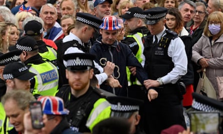 Protesters from Just Stop Oil are apprehended by police officers in the crowd near Westminster Abbey.