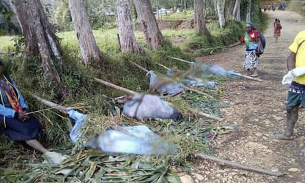 Villagers stand by the bodies of victims recovered from tribal violence in Karida, Papua New Guinea.