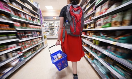 A shopper with a basket in a Tesco supermarket.