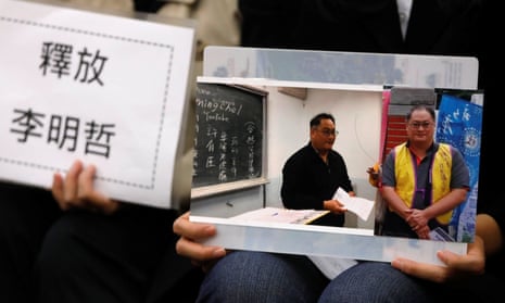 Li Ching-yu, wife of Taiwanese human right activist Li Ming-che, detained in China, holds photos of her husband at a news conference in Taipei.