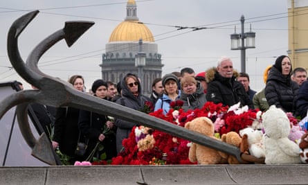 People lay flowers at a memorial in St Petersburg