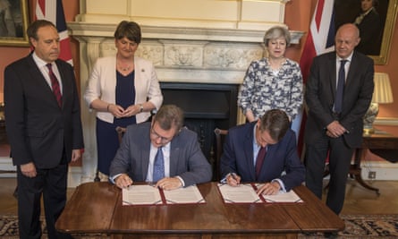 From left, Nigel Dodds, Arlene Foster, Theresa May and Damian Green watch Jeffrey Donaldson and Gavin Williamson sit and sign an agreement between the DUP and the Conservatives.