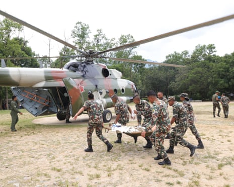 नुवाकोट जिले में नेपाल सेना के अधिकारी हेलीकॉप्टर से बाढ़ से बचे लोगों को बचा रहे हैं