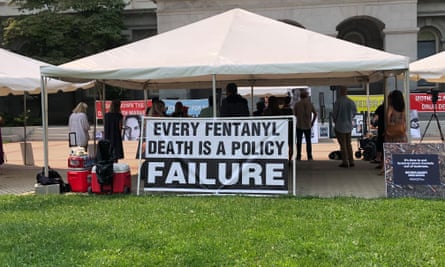 people under a tent with a sign that says ‘every fentanyl death is a policy failure’