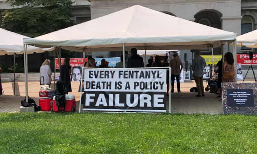 people under a tent with a sign that says 'every fentanyl death is a policy failure'