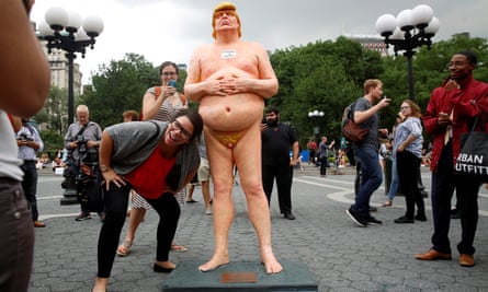 People photograph a naked statue of Donald Trump that was left in Union Square Park in New York City.