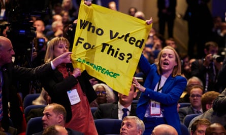 Rebecca Newsom and Ami McCarthy of Greenpeace UK with a yellow banner that says: ‘Who voted for this?’